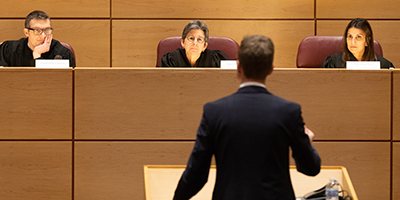 Student speaking to judges in a courtroom setting